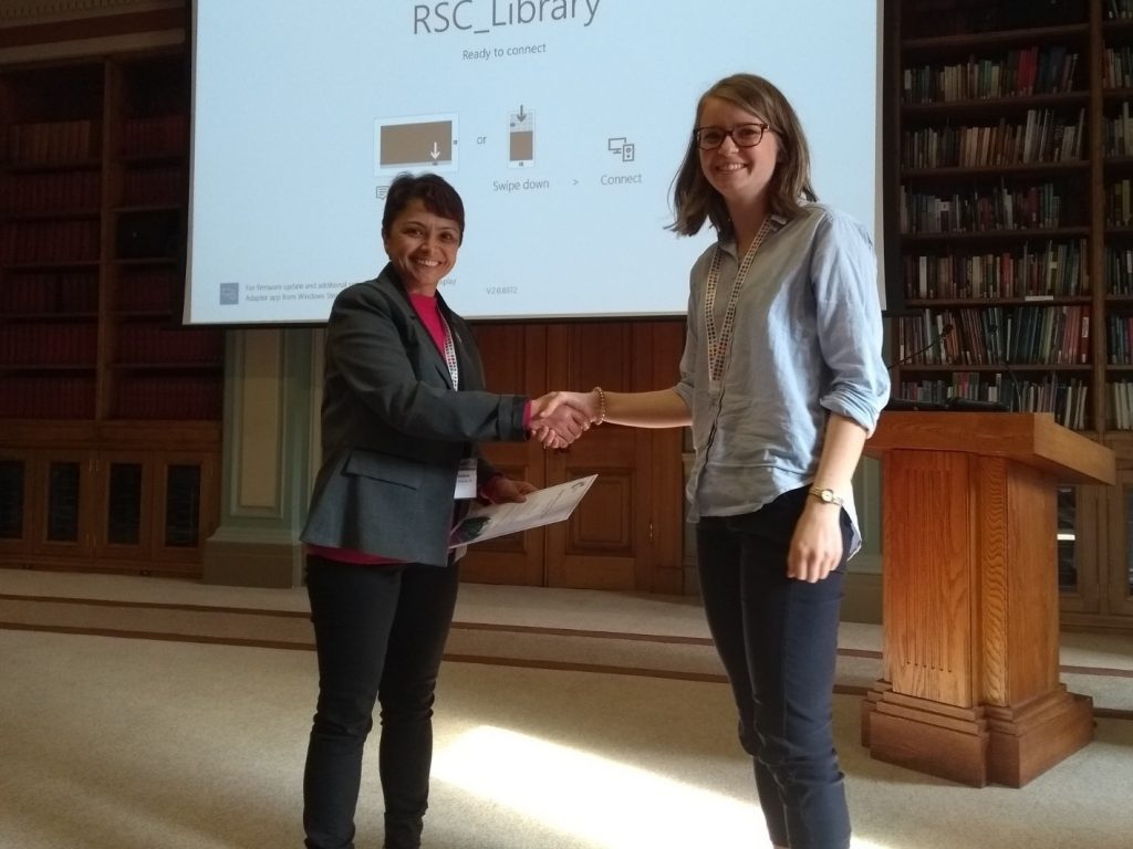 Caitlin McManus, University of Oxford, being presented with her prize certificate by Pooja Goddard (RSC Dalton/Loughborough University). Photo © Royal Society of Chemistry